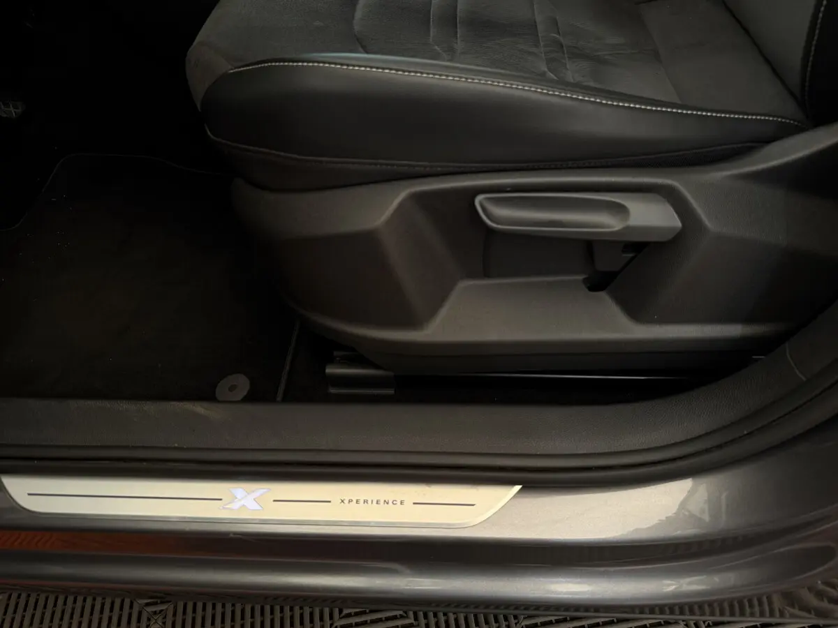 Gros plan sur la marche d'entrée côté conducteur du SEAT Ateca gris clair version Xperience avec logo lumineux Xperience.