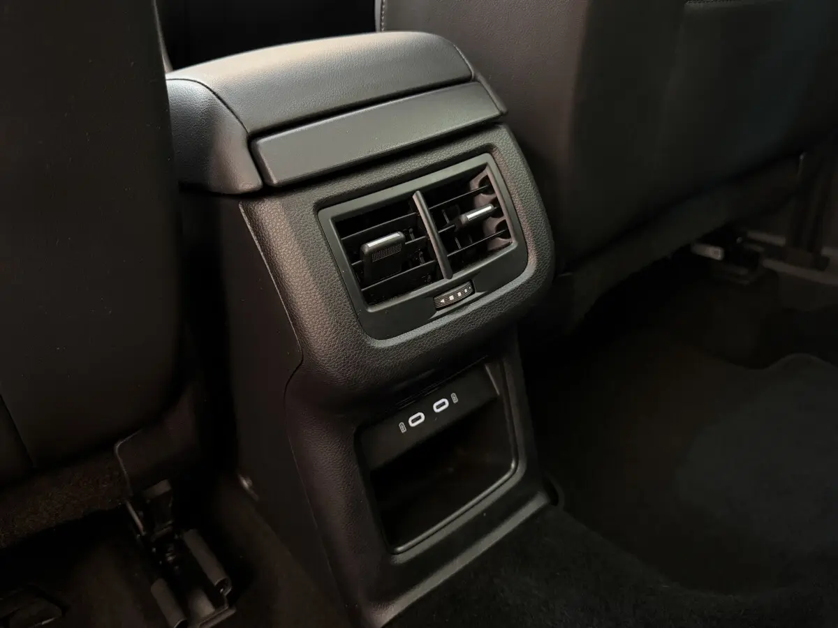 Vue rapprochée des aérateurs arrière et ports USB noirs dans l’habitacle du SEAT Ateca gris clair 2023.