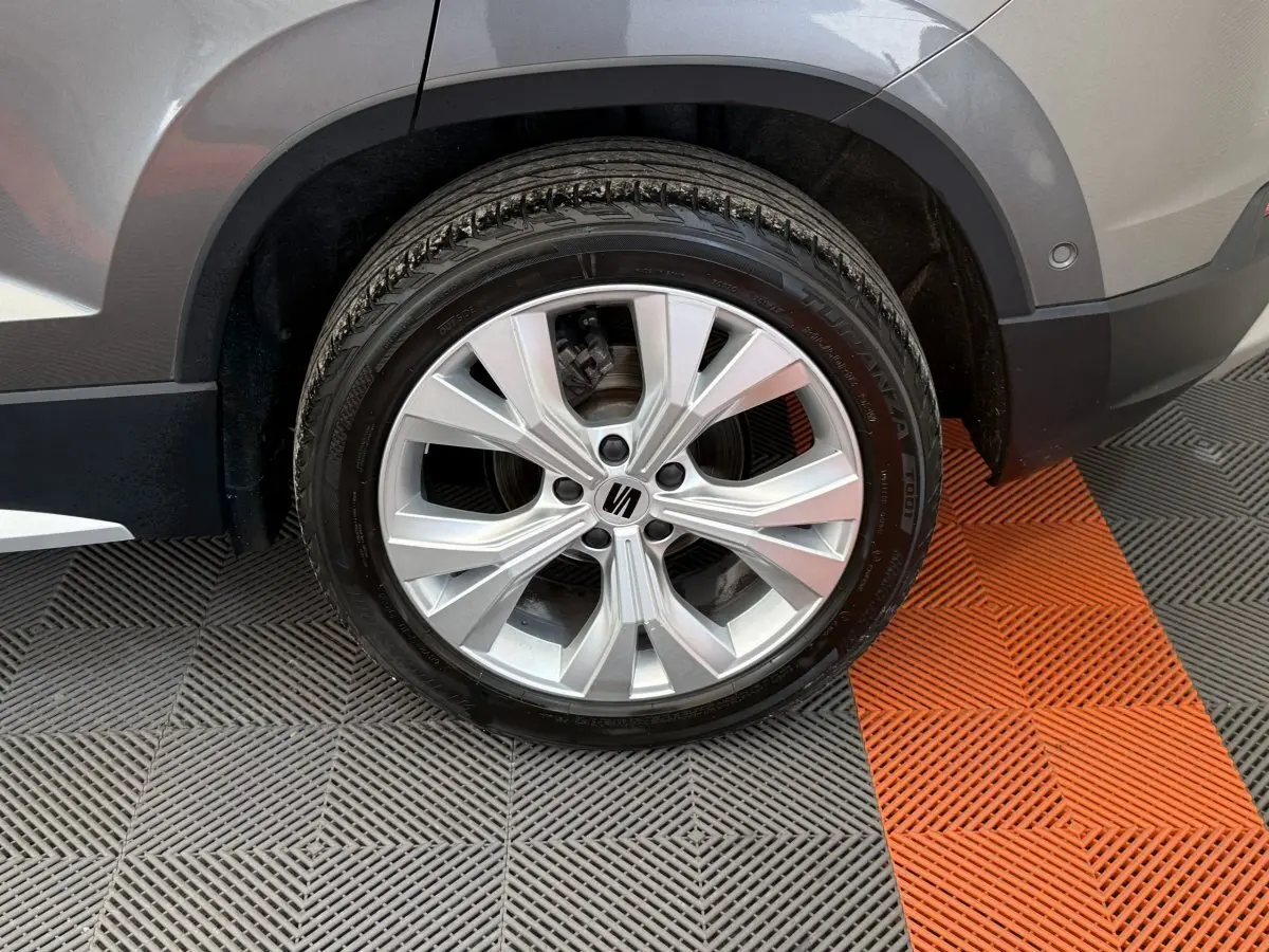 Gros plan sur la roue avant droite gris clair du SEAT Ateca 2023 avec jante alliage et logo central visible.