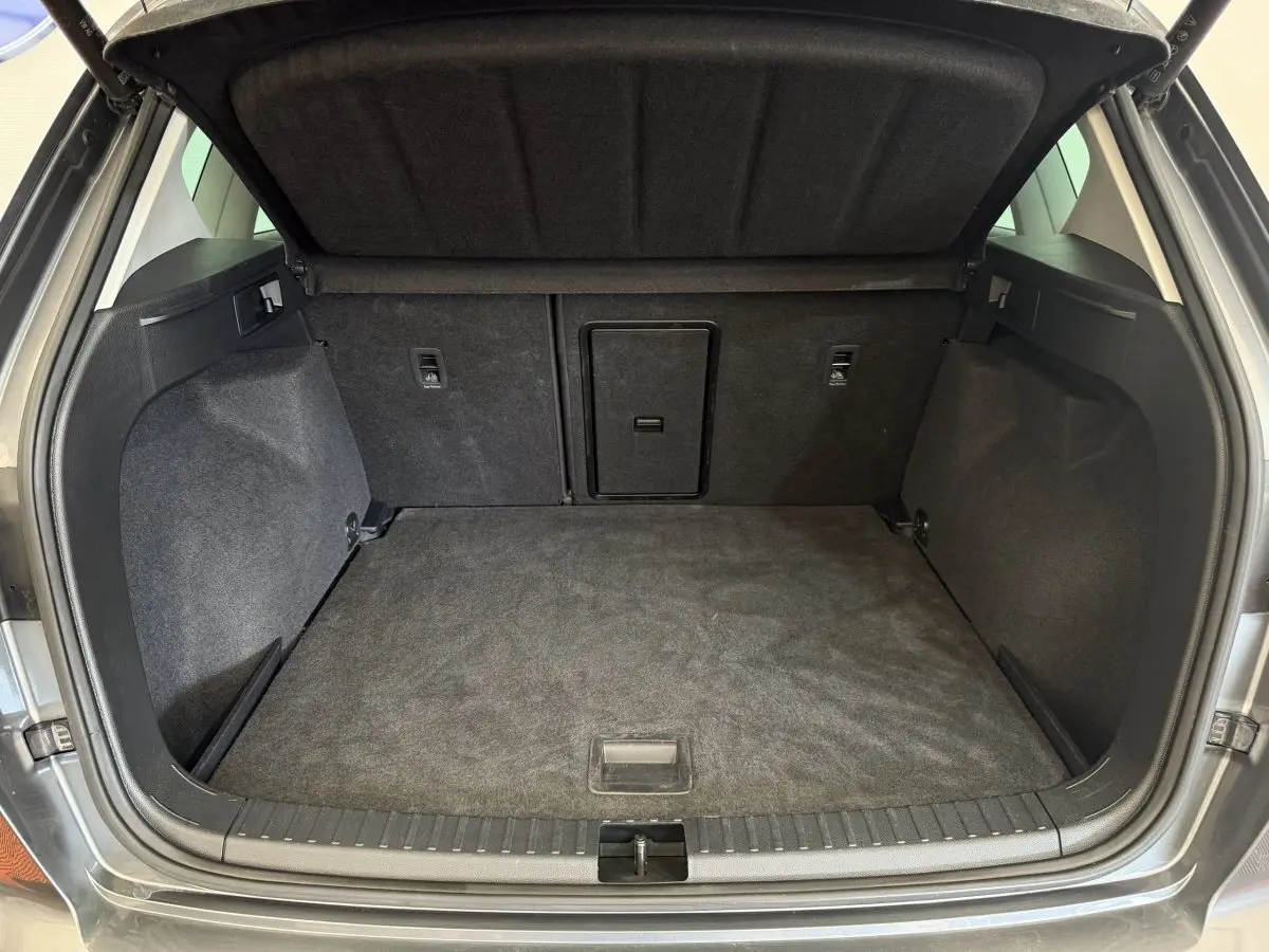 Coffre ouvert gris clair du SEAT Ateca 2023, vue arrière montrant un espace de chargement propre et spacieux.