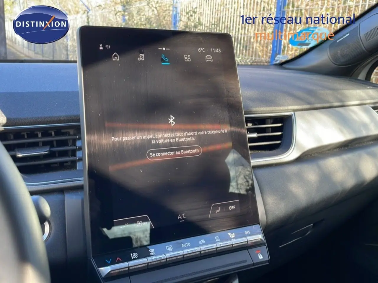 Vue intérieure centrée sur l’écran tactile vertical du tableau de bord du Renault Captur gris Rafale toit noir.