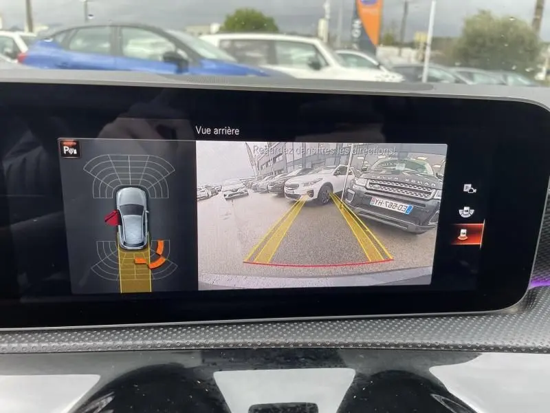Écran de caméra de recul d’une Mercedes Classe A 2019 gris foncé, vue arrière avec lignes de guidage jaunes.