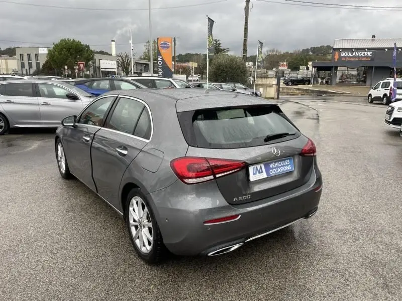 Vue 3/4 arrière droite d'une Mercedes Classe A 200 gris foncé métal, avec feux arrière LED et jantes argentées.