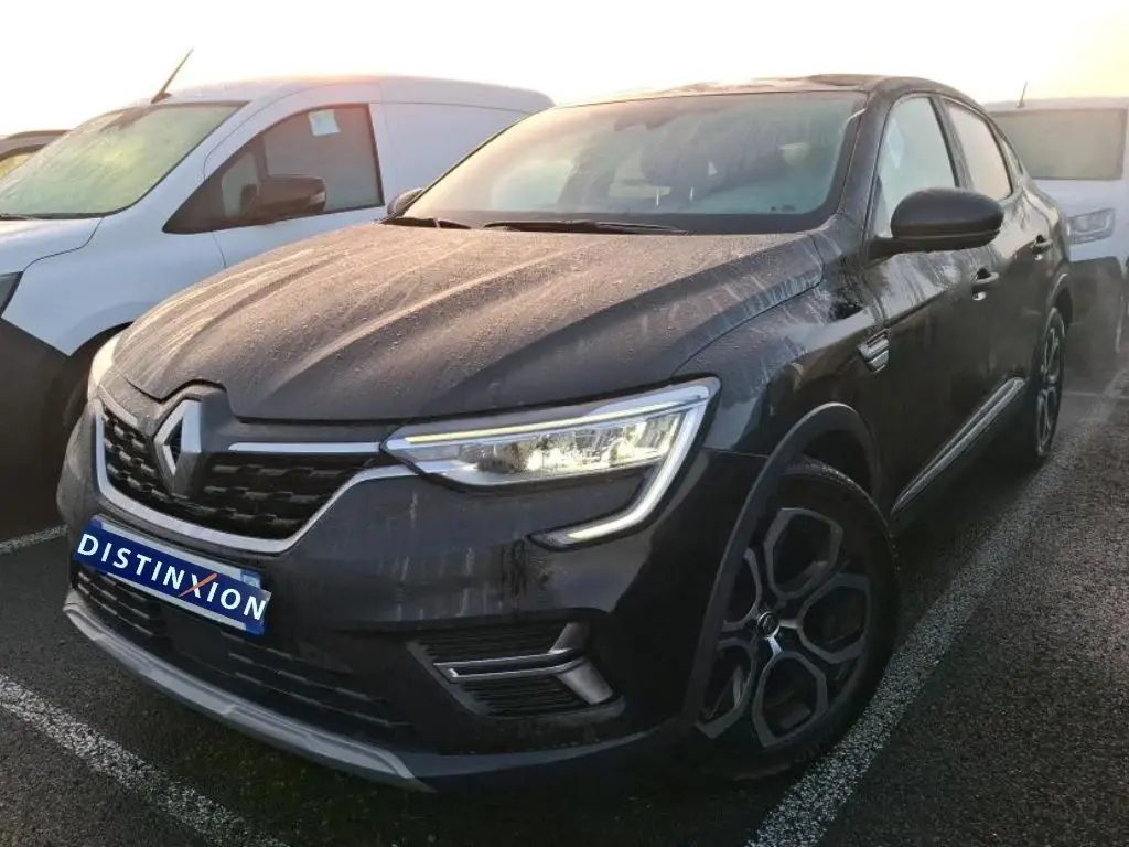 Renault Arkana 1.6 E-Tech hybride noir métal vu en 3/4 avant droit, avec feux allumés et jantes spécifiques.