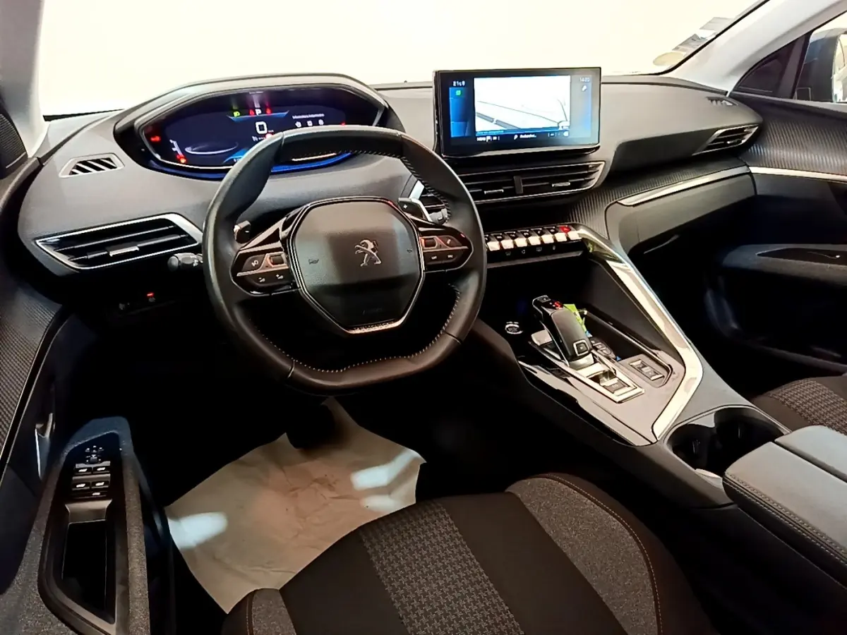 Vue intérieure avant du Peugeot 5008 2021, volant cuir multifonctions et écran tactile central allumé.