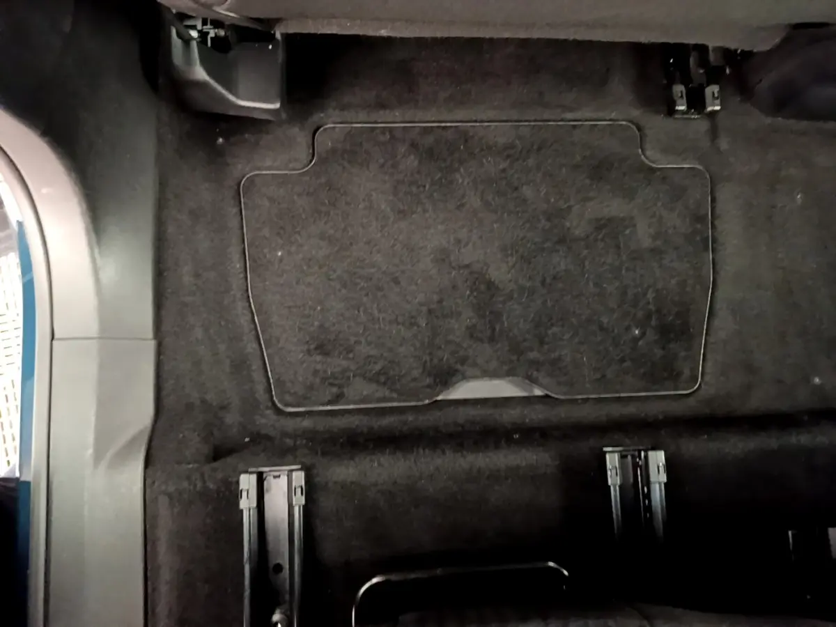 Vue intérieure du plancher arrière noir du Peugeot 5008 2021 sans sièges, montrant les rails d'ancrage des sièges amovibles.