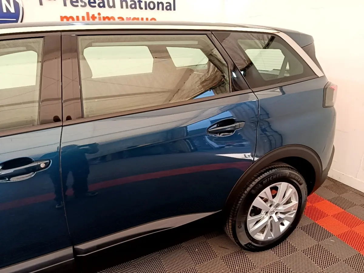 Vue latérale droite du Peugeot 5008 bleu 2021, mettant en valeur la porte arrière et la roue arrière.
