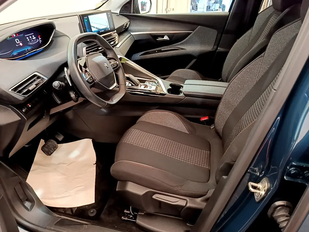 Vue intérieure côté conducteur du Peugeot 5008 bleu 2021, volant cuir multifonctions et tableau de bord numérique.