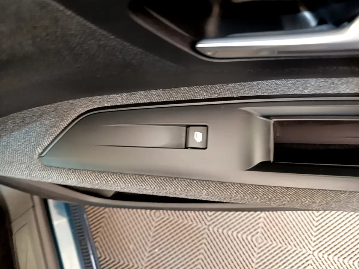 Détail de la commande de verrouillage de porte sur la portière côté conducteur d’un Peugeot 5008 bleu.