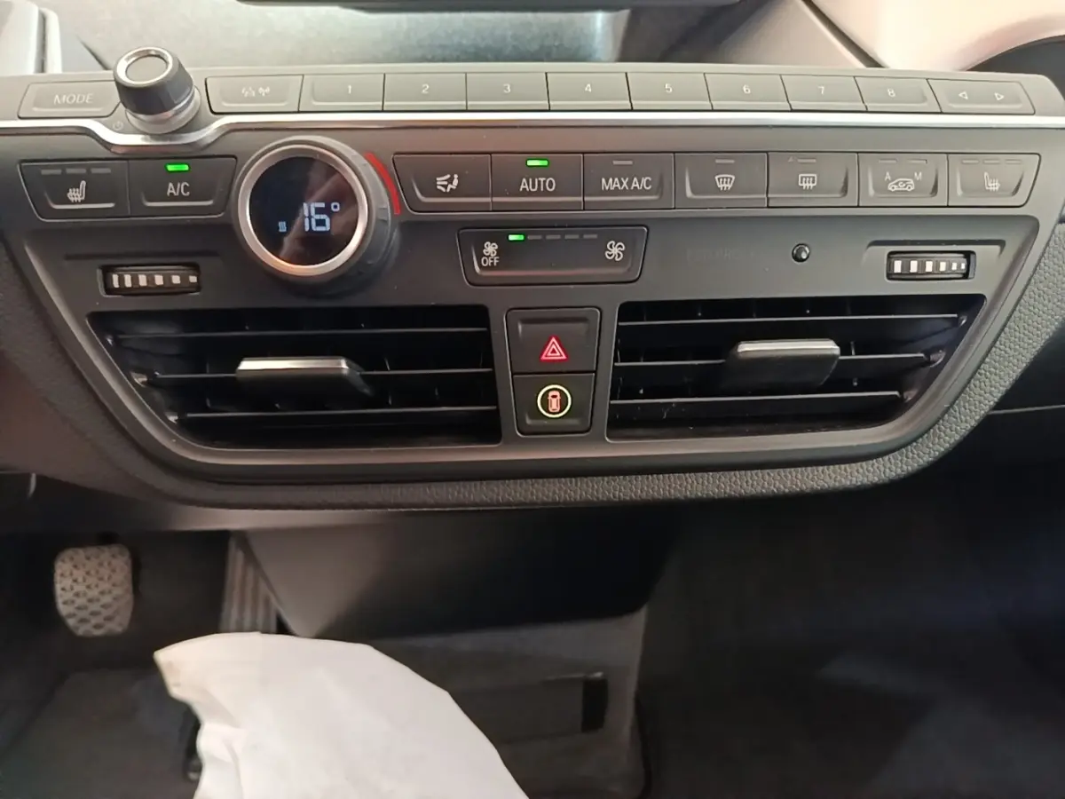 Vue rapprochée du tableau de bord noir de la BMW i3 120 Ah 2020, avec commandes climatisation et ventilation visibles.