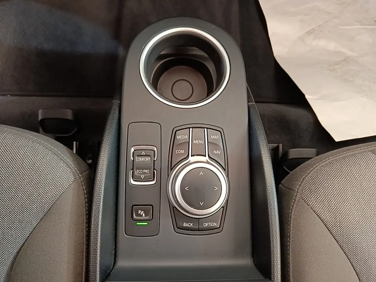 Vue plongeante sur la console centrale noire du BMW i3 120 Ah avec molette de contrôle et boutons de mode de conduite.
