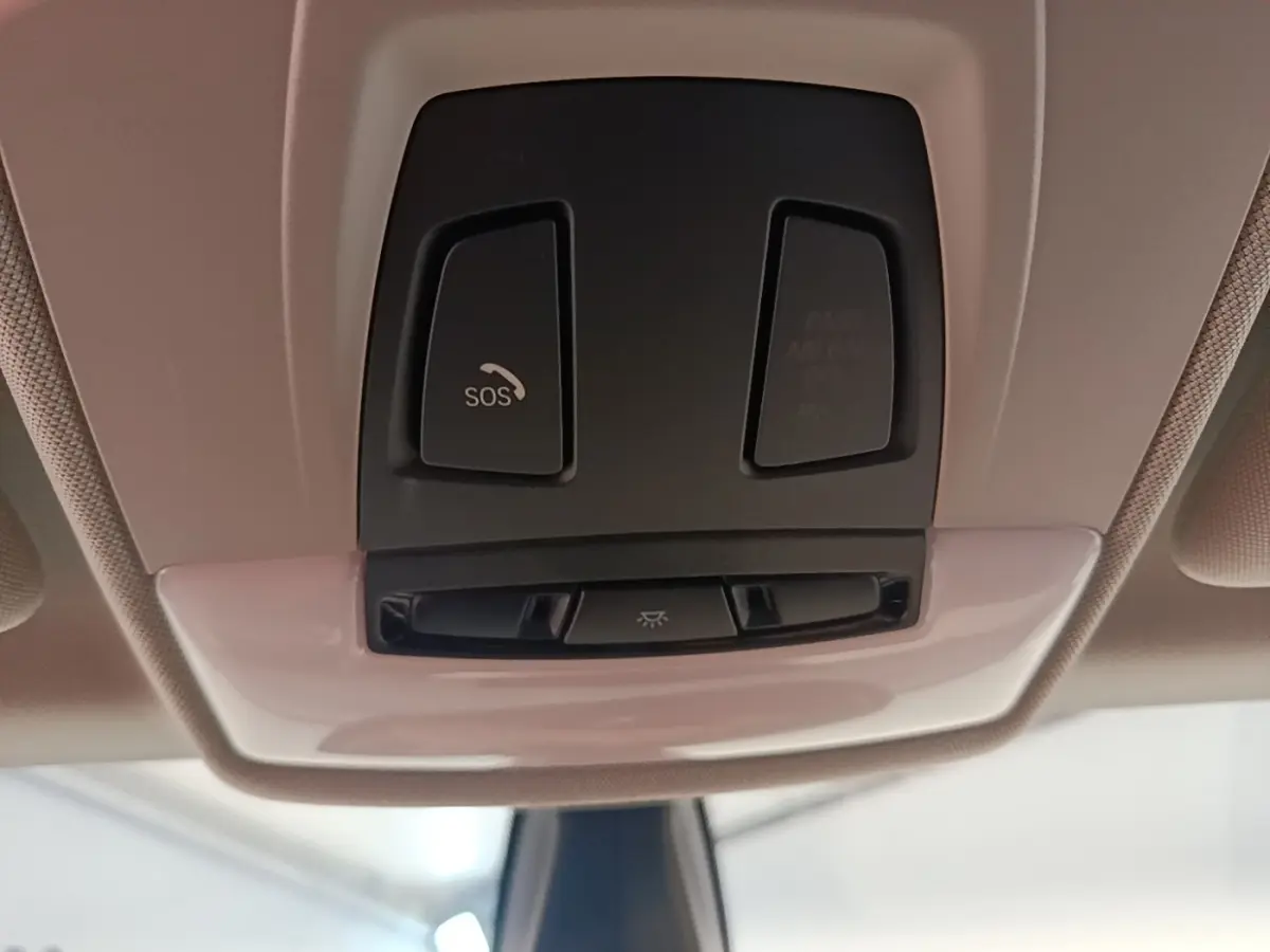 Vue en gros plan du plafonnier intérieur noir de la BMW i3 120 Ah Atelier avec bouton SOS visible.