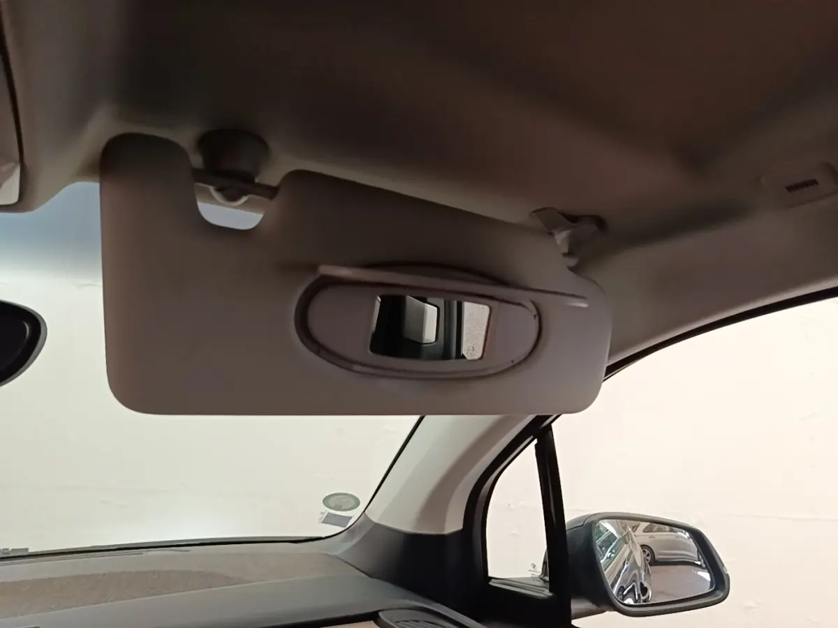 Détail du pare-soleil côté conducteur avec miroir intégré dans l’habitacle clair d’une BMW i3 noire de 2020.
