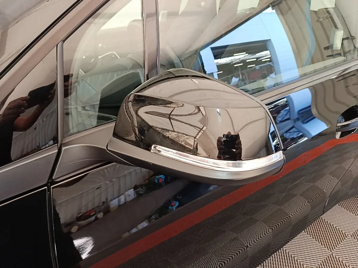 Rétroviseur côté gauche noir brillant de la BMW i3 120 Ah Atelier 2020 avec carrosserie noire réfléchissante.