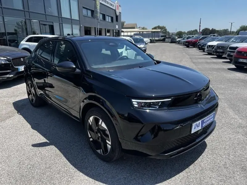 Opel Mokka Electric 156 GS noir vue 3/4 avant droit, avec jantes spécifiques et calandre épurée électrique.