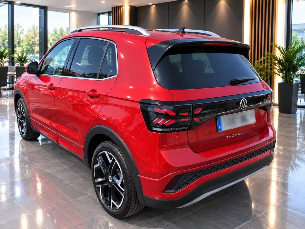 Vue 3/4 arrière droite d’un Volkswagen T-Cross rouge métallisé avec jantes alliage noires et toit argenté en intérieur showroom.