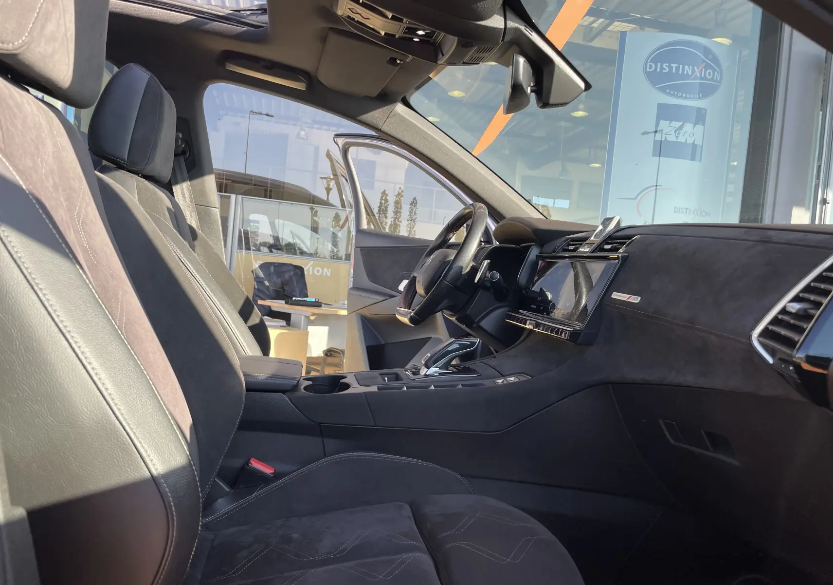 Intérieur côté conducteur du DS7 gris Artens 2018, avec sièges en cuir et alcantara, tableau de bord moderne et toit ouvrant panoramique.