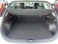 Coffre ouvert du Kia Niro EV 204 CV Active blanc 2024, vue arrière montrant l'espace de chargement vide.