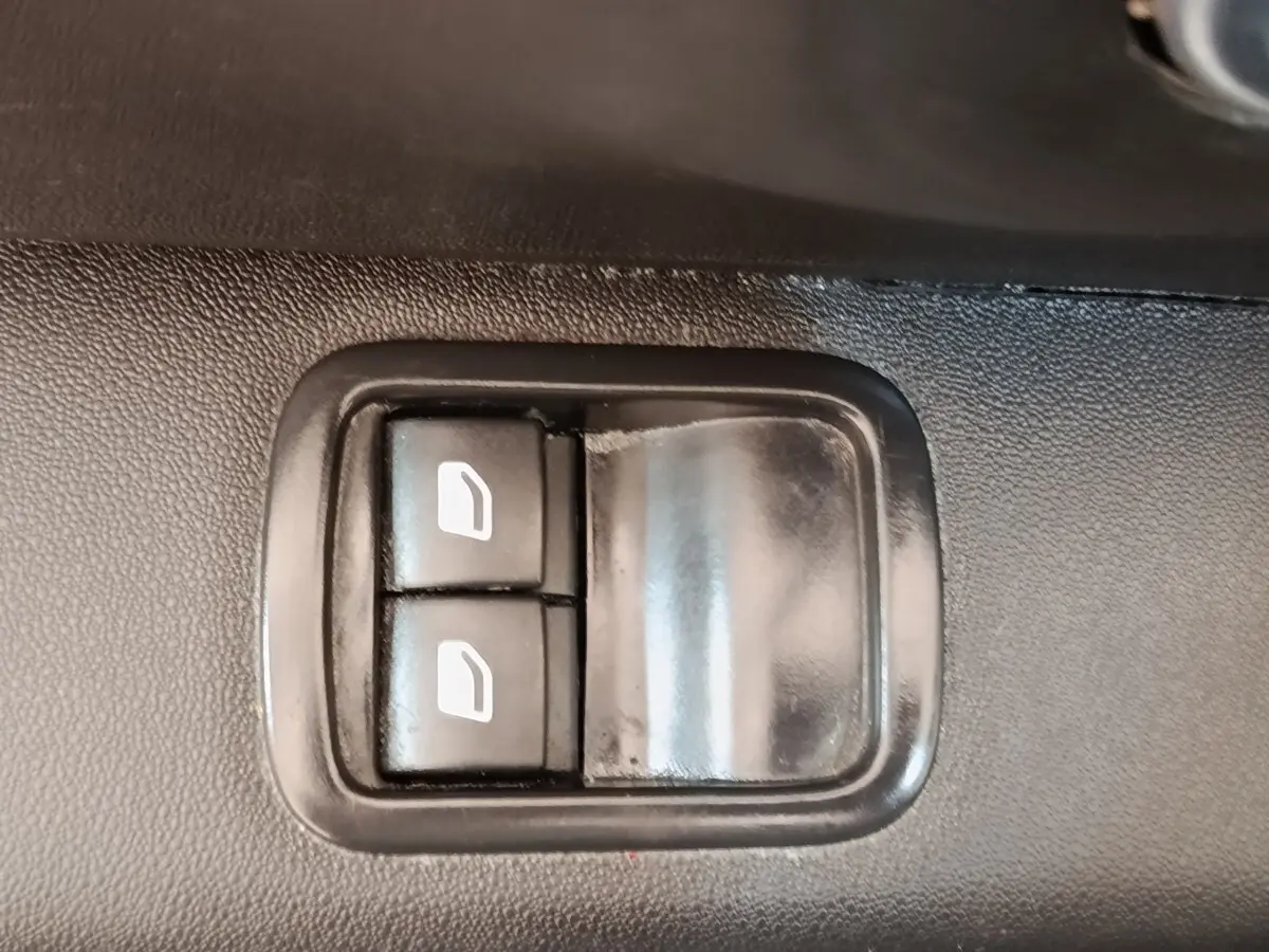 Boutons de commande des vitres électriques sur la porte intérieure d'une Citroën C3 blanche, version PureTech 83 S&S BVM Feel Nav.