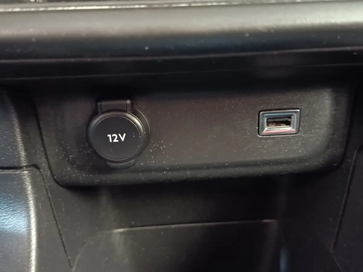 Prise 12V et port USB intégrés dans la console centrale noire d'une Citroën C3 blanche.