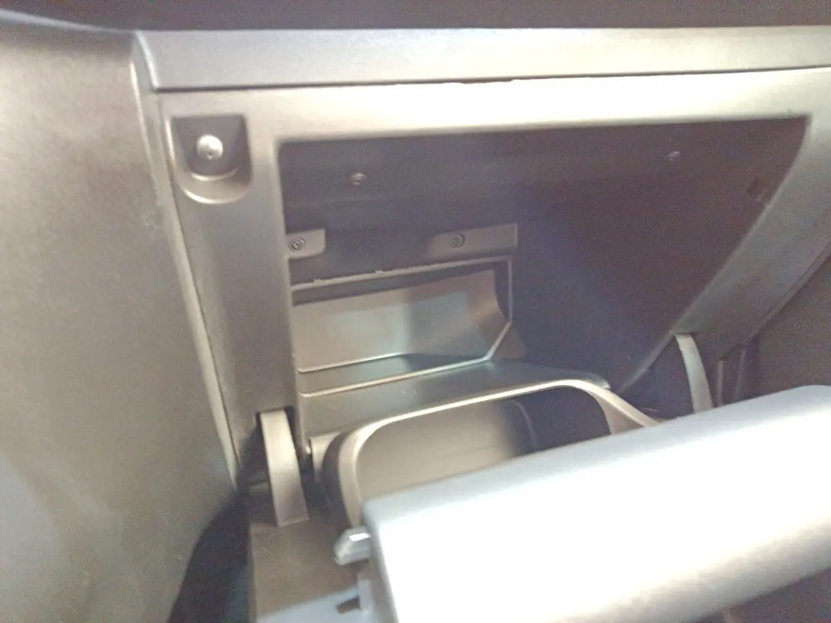 Gros plan sur la boîte à gants ouverte de la Citroën C3 blanche, intérieur noir mat, côté passager.