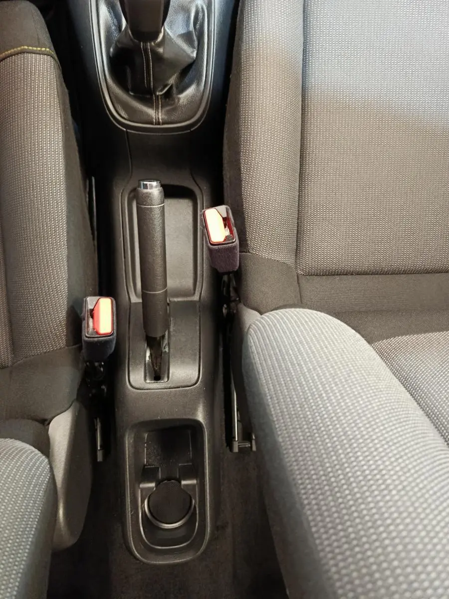Vue plongeante sur la console centrale et les sièges gris foncé de la Citroën C3 PureTech 2022, avec frein à main manuel.