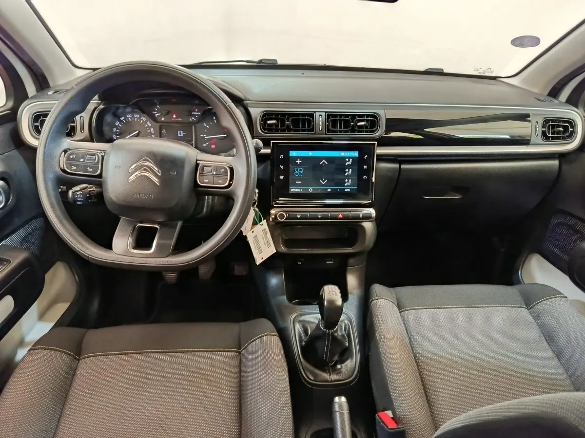 Vue intérieure avant du tableau de bord et volant noir de la Citroën C3 PureTech 83 de 2022 avec écran tactile central.