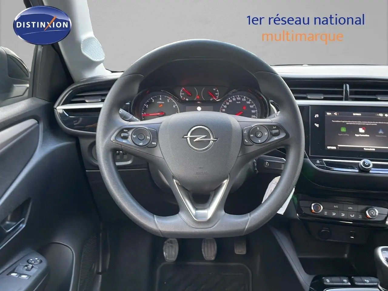 Vue intérieure centrée sur le volant Opel de la Corsa 1.5 Turbo D 102ch, avec tableau de bord et écran tactile visibles.