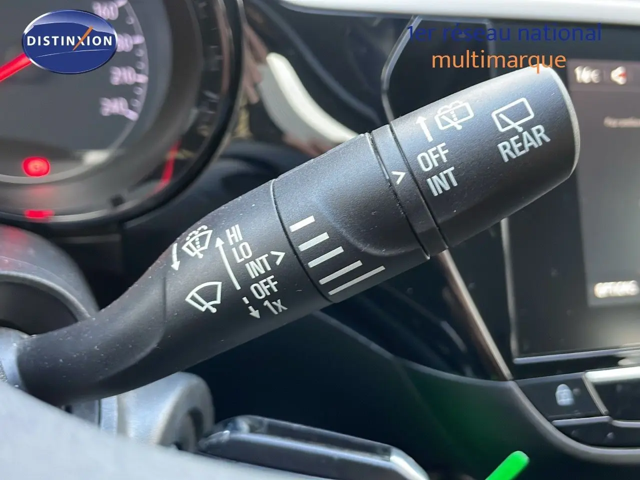 Gros plan sur la commande d’essuie-glace à gauche du volant dans l’habitacle d’une Opel Corsa gris Kristall Metal.