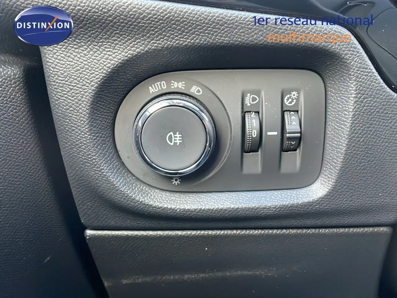 Gros plan sur les commandes d’éclairage intérieures d’une Opel Corsa gris Kristall Metal, tableau de bord noir.