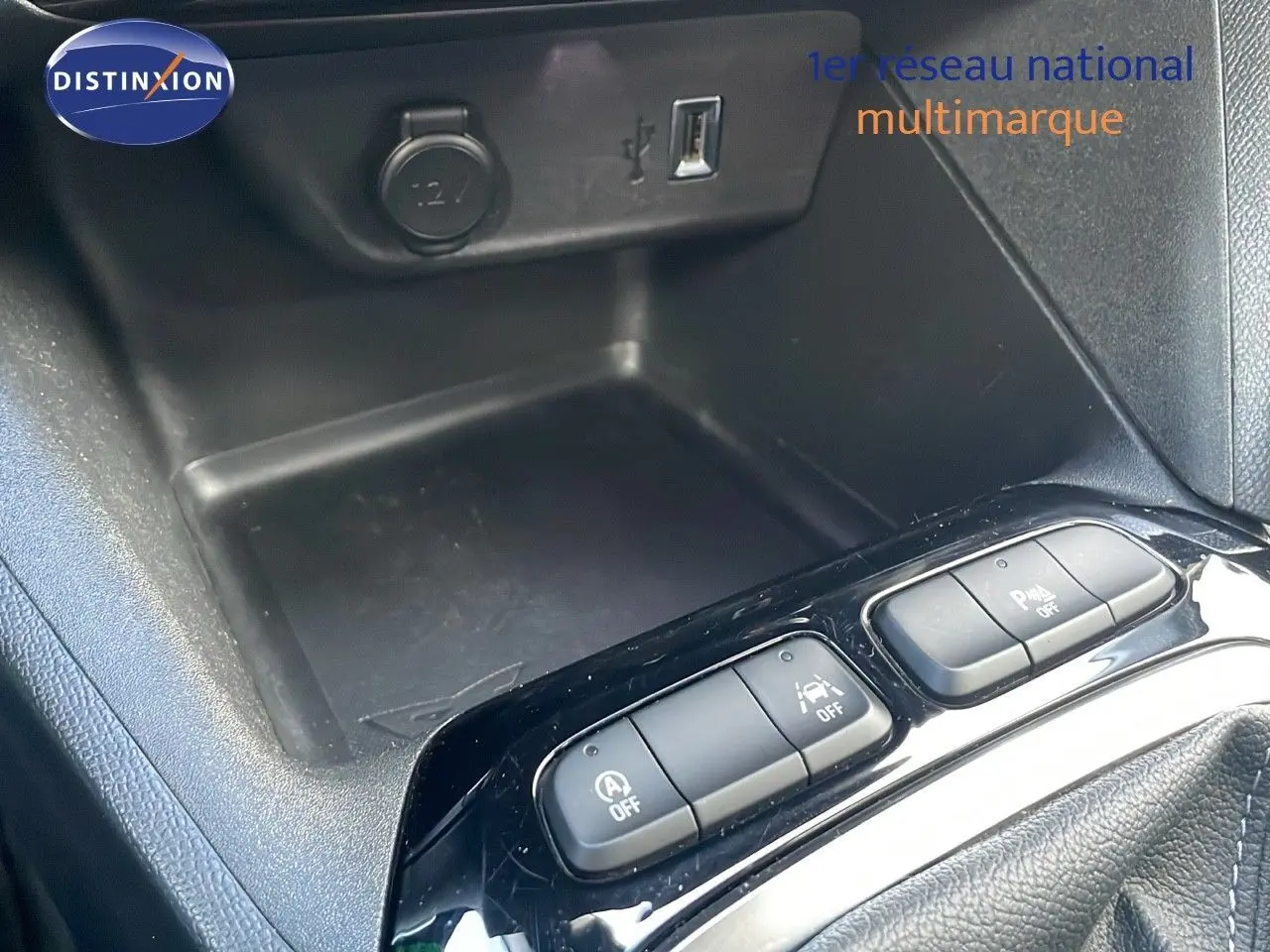 Vue rapprochée de la console centrale noire de l’Opel Corsa gris Kristall Metal, avec boutons de contrôle et prise USB.