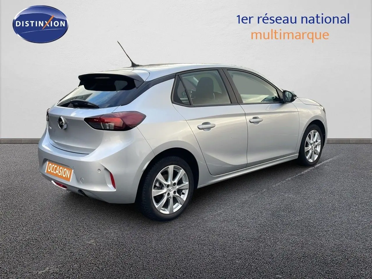 Vue 3/4 arrière droite d'une Opel Corsa gris kristall metal 2022 à cinq portes avec jantes alliage et toit noir.