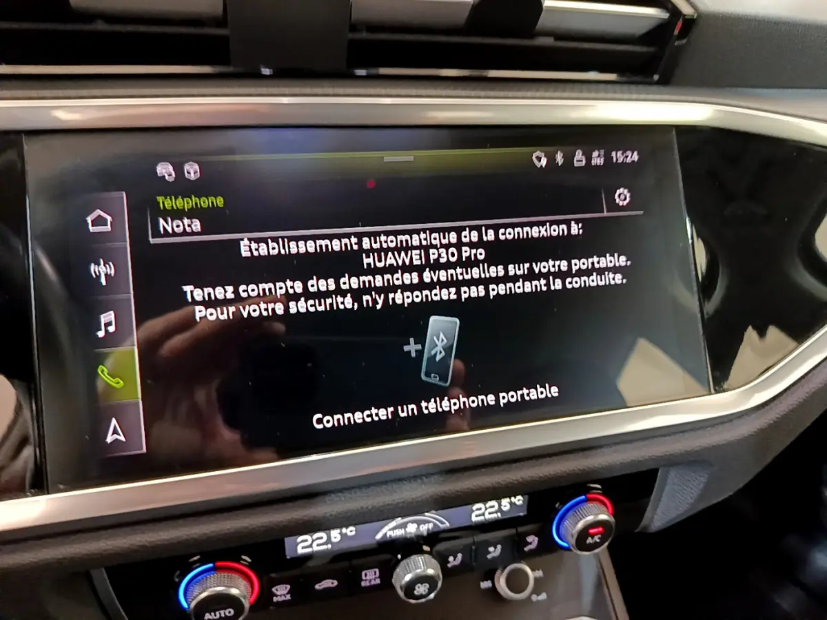 Écran tactile central affichant la connexion Bluetooth dans l'Audi Q3 noir, vue intérieure du tableau de bord.