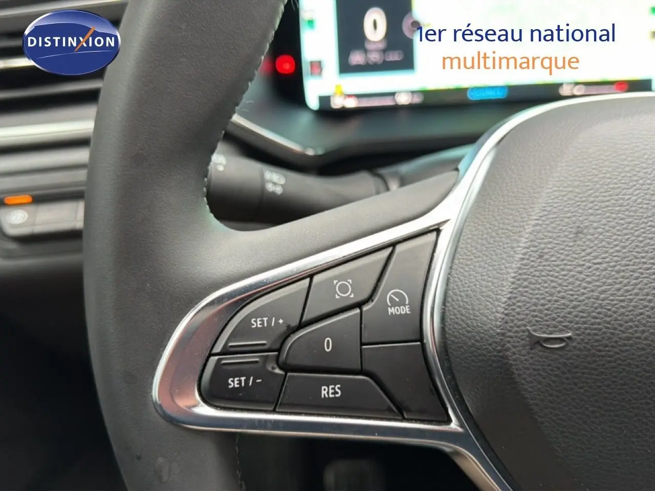 Gros plan sur les commandes au volant côté gauche du Renault Captur bleu Iron Metal avec toit noir, tableau de bord numérique en arrière-plan.