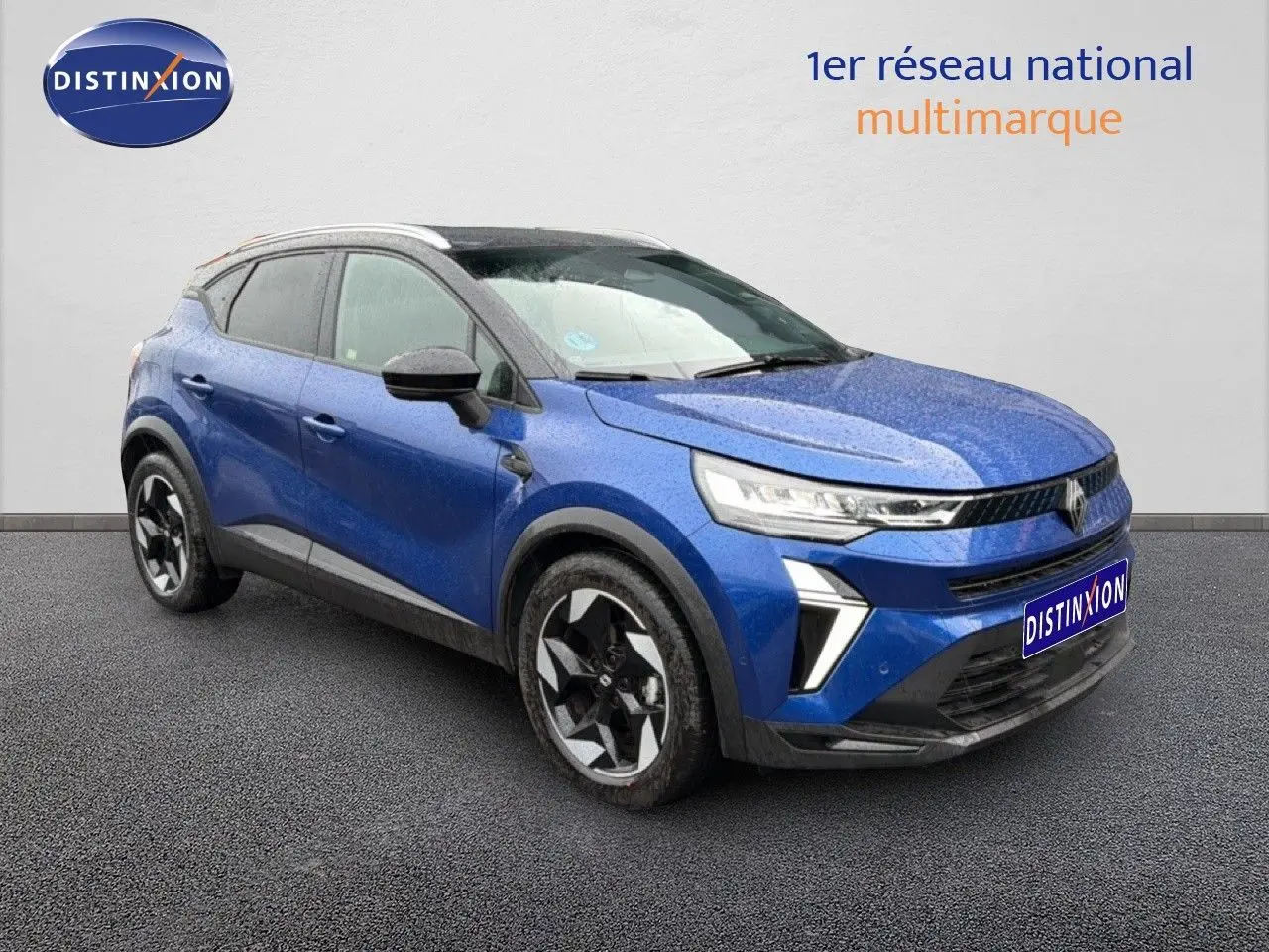 Renault Captur 2025 bleu Iron Metal avec toit noir, vue 3/4 avant mettant en valeur les feux LED et jantes bicolores.