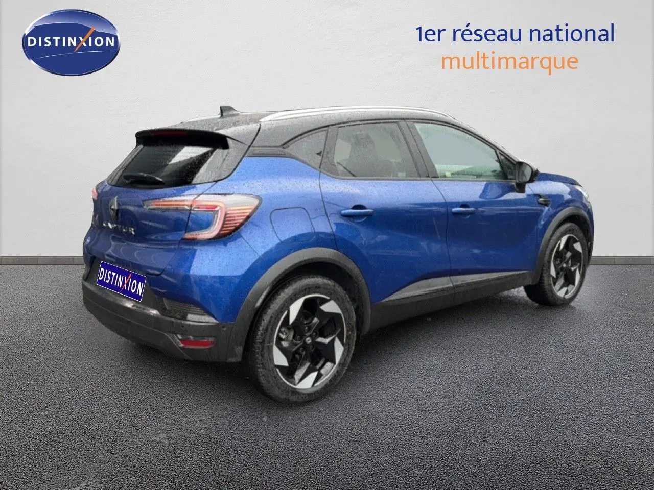Renault Captur 2025 bleu Iron Metal avec toit noir, vue 3/4 arrière côté droit, jantes alliage distinctives.