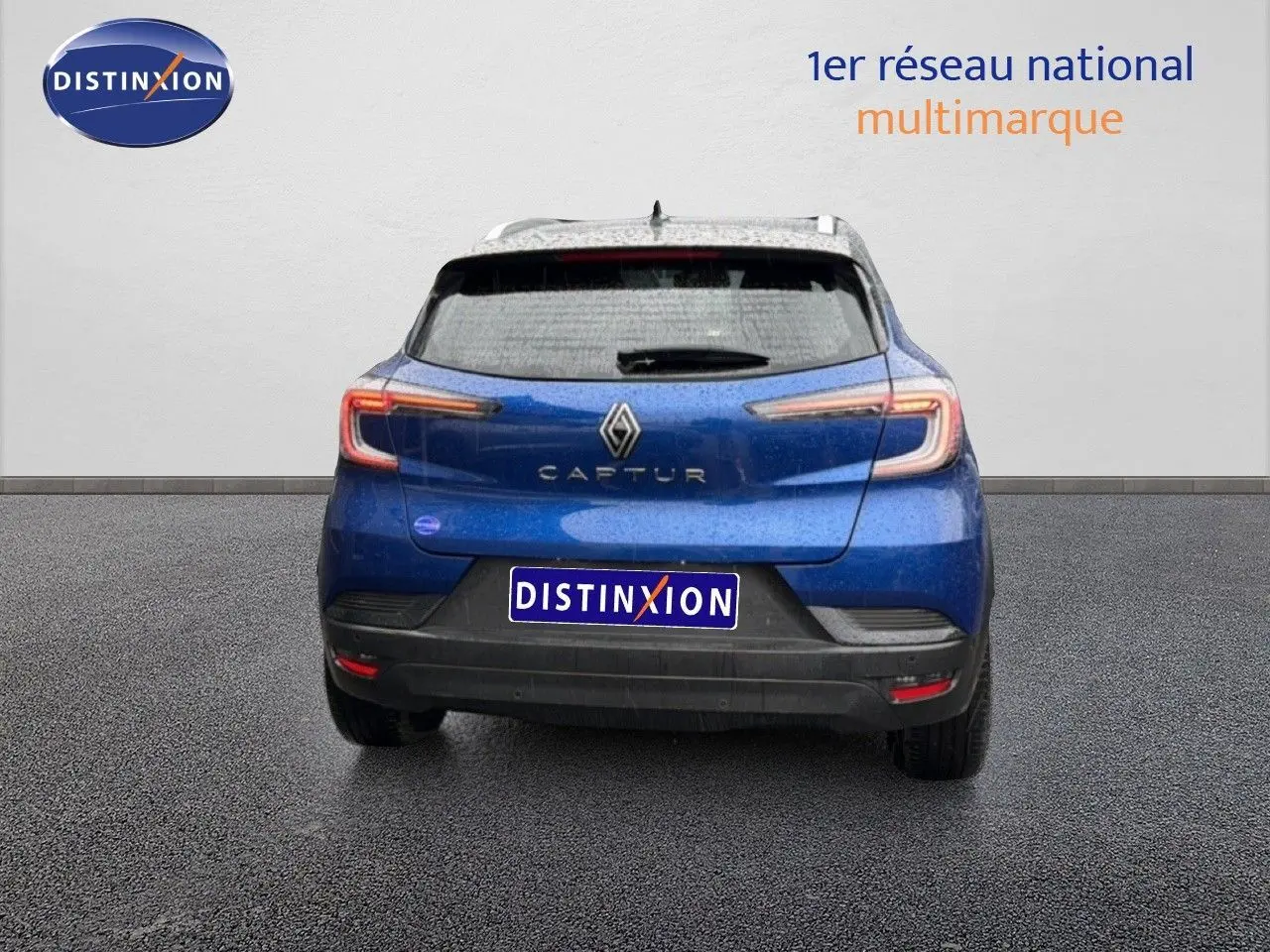 Vue arrière d’un Renault Captur bleu Iron Metal avec toit noir, feux arrière LED et plaque Distinxion.