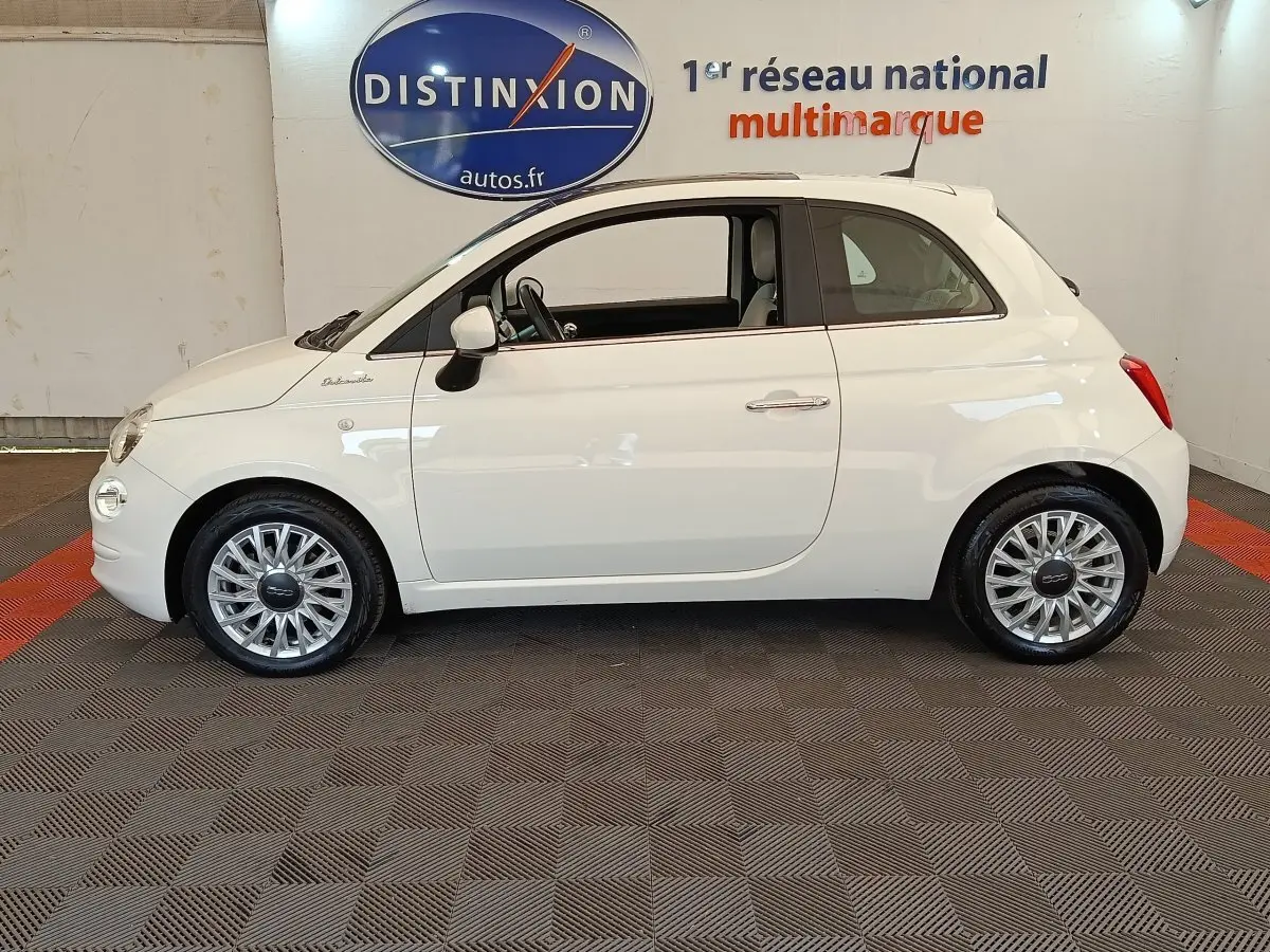 Profil latéral droit d'une Fiat 500 blanche Dolcevita 2022, avec jantes alliage et vitrage teinté.