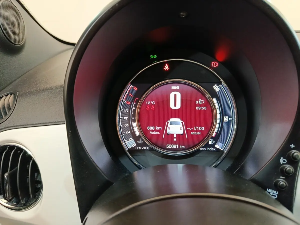 Vue rapprochée du tableau de bord numérique rond de la Fiat 500 blanche, affichant la vitesse à 0 km/h.