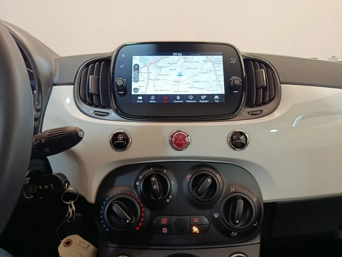 Tableau de bord blanc de Fiat 500 Hybrid 2022 avec écran tactile central affichant une carte de navigation.