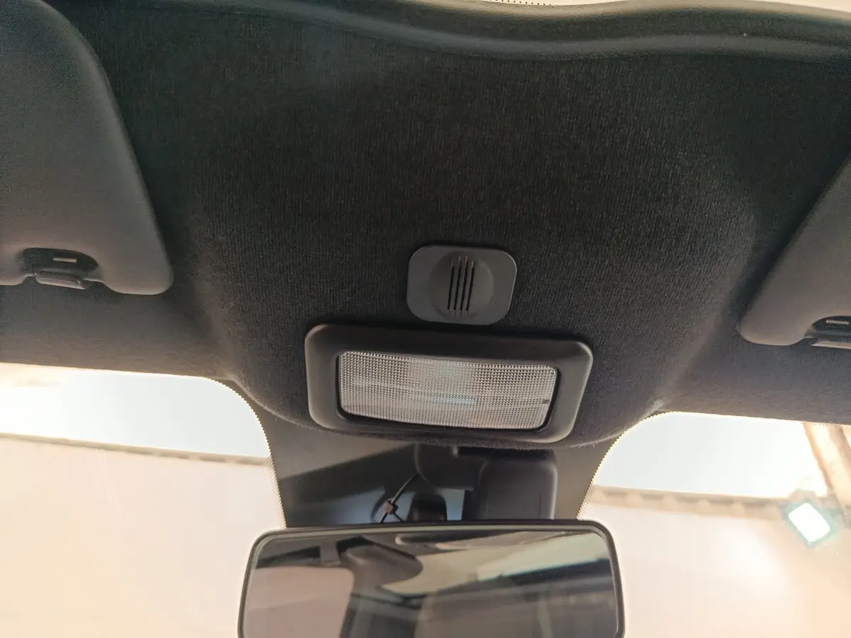 Vue intérieure centrée sur le plafonnier et le rétroviseur d'une Fiat 500 blanche, version Hybrid Dolcevita 2022.