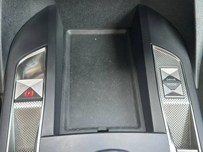 Gros plan sur la console centrale du DS3 2024, boutons de frein à main électronique et mode de conduite avec finitions texturées métalliques.