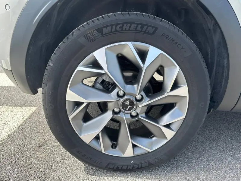 Gros plan sur la roue avant gauche de la DS3 2024 en Cristal Pearl, jante alliage au design géométrique distinctif.
