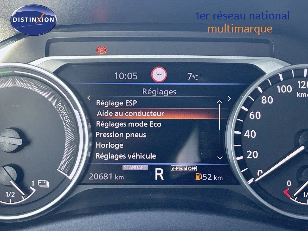 Tableau de bord numérique du Nissan Juke gris, affichant les réglages et la vitesse au ralenti.