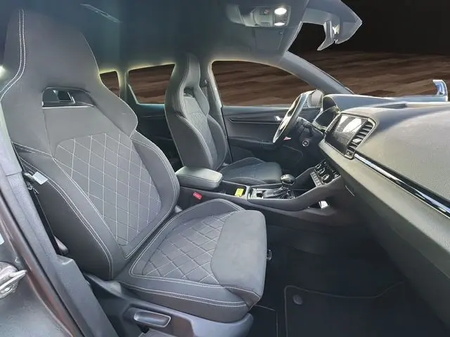 Vue intérieure côté gauche du Skoda Karoq 2025 gris graphite, mettant en valeur les sièges sport noirs et la console centrale.