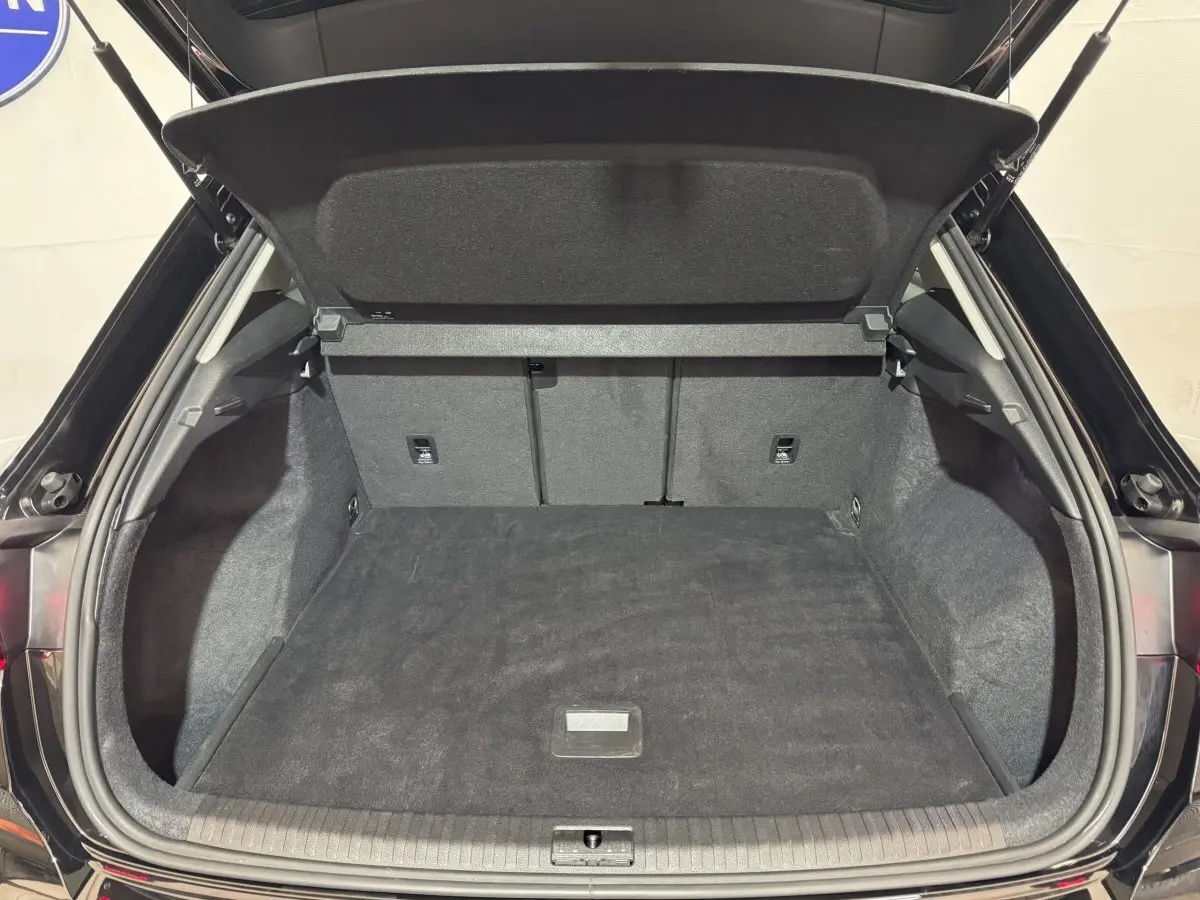 Coffre ouvert vu de l'arrière d'un Audi Q3 noir 2022, montrant un espace de chargement propre et spacieux.