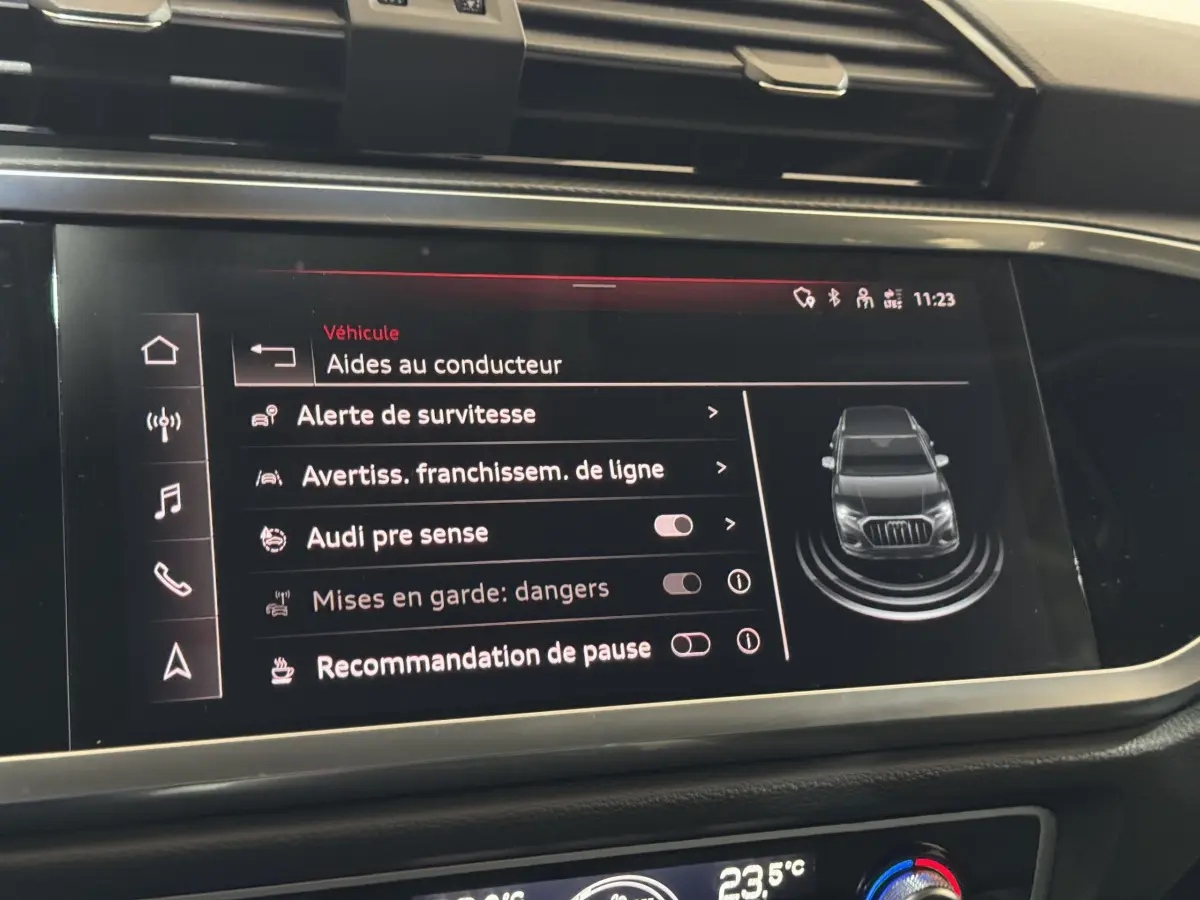 Écran tactile intérieur de l'Audi Q3 noir 2022 affichant les aides au conducteur et options de sécurité.