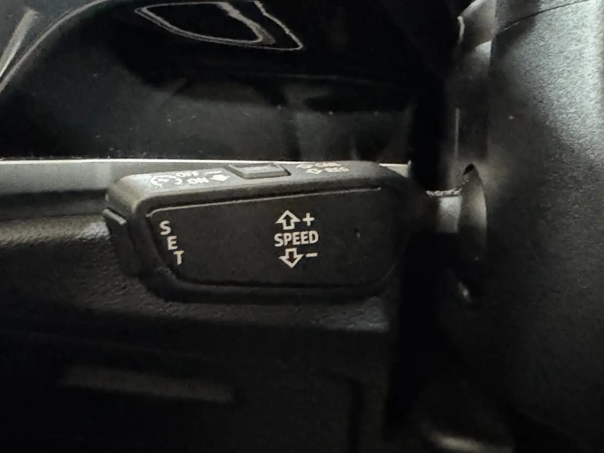 Gros plan sur la commande de régulateur de vitesse du volant noir de l'Audi Q3 35 TFSI 2022.