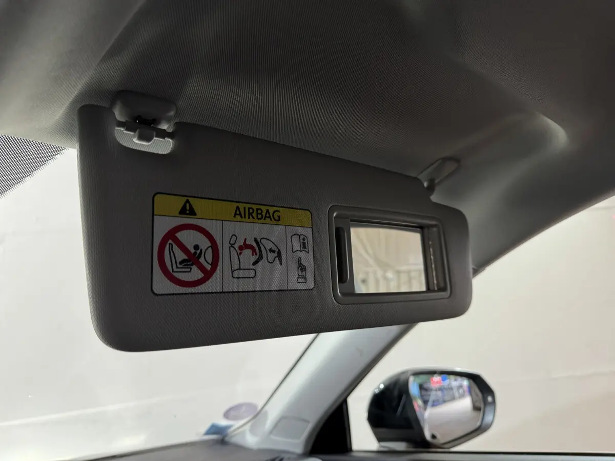 Pare-soleil côté conducteur avec miroir intégré et avertissement airbag dans l'Audi Q3 noir 2022, vue intérieure avant gauche.