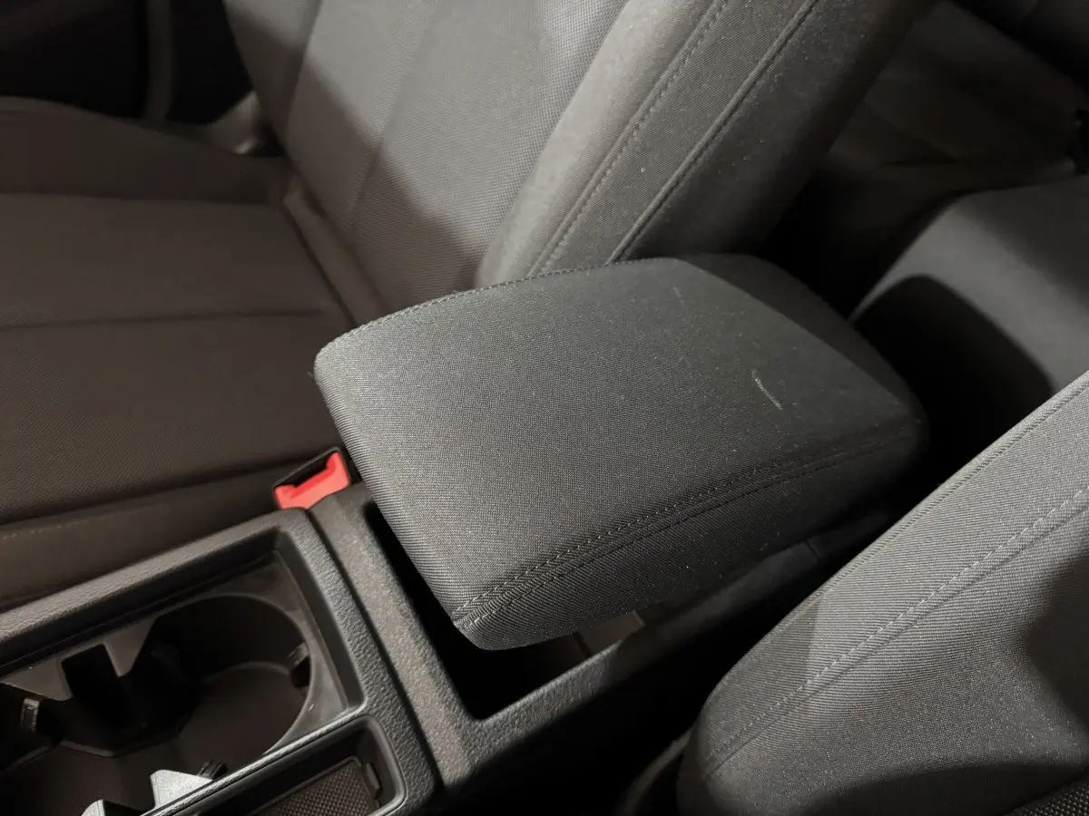 Gros plan sur l'accoudoir central noir et les sièges tissu foncé de l'Audi Q3 35 TFSI 2022.